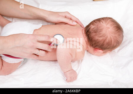 Kinderarzt untersucht zwei Wochen altes Baby zurück in der Kinderklinik. Arzt mit einem Stethoskop Herz und Lungen zu überprüfen. Neugeborene Check-up Konzept Stockfoto