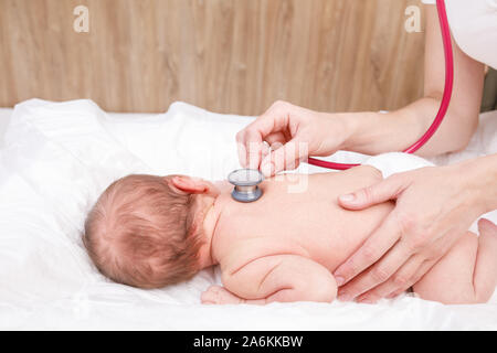 Kinderarzt untersucht zwei Wochen altes Baby zurück in der Kinderklinik. Arzt mit einem Stethoskop Herz und Lungen zu überprüfen. Neugeborene Check-up Konzept Stockfoto