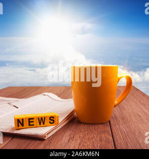 Gute Nachrichten am Morgen Zeit collage Bild. Becher Kaffee und Zeitung auf hölzernen Tisch bei Sonnenaufgang Stockfoto