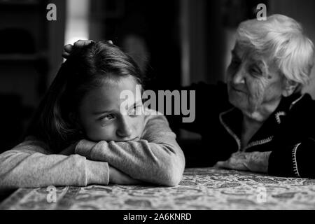 Alte Frau tröstend eine schreiende Mädchen Enkelin. Schwarz-weiß-Foto. Stockfoto