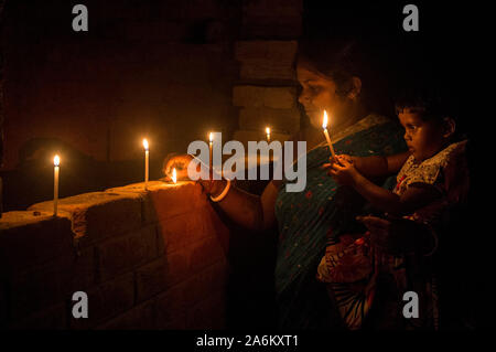 Kolkata, Indien. 27 Okt, 2019. Eine Frau und ihr Kind Kerzen in einem Dorf etwa 160 km entfernt von Kolkata, Indien, am Okt. 27, 2019. Das Festival der Lichter', oder 'eepawali Diwali, wird in Indien am Sonntag gefeiert, mit Häusern mit bunten Lichtern und irdenen Lampen geschmückt, und die Menschen den Austausch von Süßigkeiten und platzen Böller. Quelle: Xinhua/Alamy leben Nachrichten Stockfoto