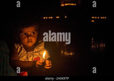 Kolkata, Indien. 27 Okt, 2019. Ein Kind leuchten Kerzen in einem Dorf etwa 160 km entfernt von Kolkata, Indien, am Okt. 27, 2019. Das Festival der Lichter', oder 'eepawali Diwali, wird in Indien am Sonntag gefeiert, mit Häusern mit bunten Lichtern und irdenen Lampen geschmückt, und die Menschen den Austausch von Süßigkeiten und platzen Böller. Quelle: Xinhua/Alamy leben Nachrichten Stockfoto