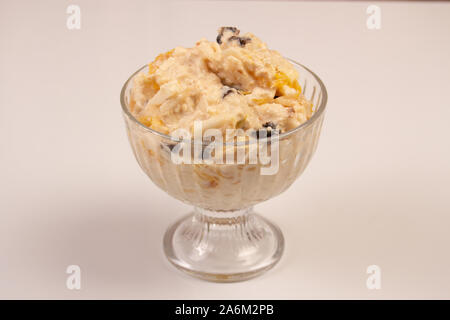 Salat von Apple, Orange, oat Hopfen und Pflaumen mit Honig in einem Glas Platte auf einem weißen Hintergrund. Stockfoto