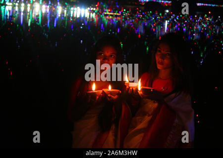 Zwei junge Mädchen aus Bangladesch halten Öllampen, wie sie für ein Foto während der Diwali-fest stellt an einem Tempel in Dhaka. Die Diwali Festival der Lichter den Sieg des Guten über das Böse symbolisiert, zum Gedenken an Herrn Ram's Rückkehr zu seinem Königreich Ayodhya nach seiner 14-jährigen Abschluss im Exil. Stockfoto