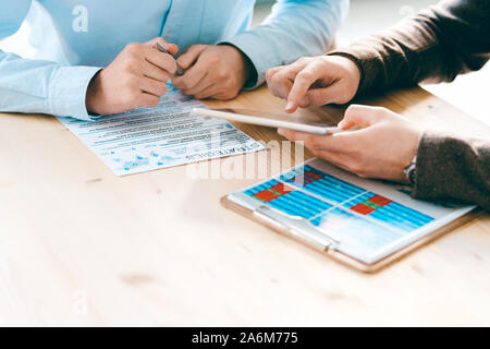 Zwei junge männliche Analysten diskutieren neue geschäftliche oder finanzielle Strategien Stockfoto