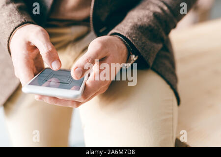 Junge zeitgenössische Geschäftsmann Scrollen durch elektronische Dokumente Stockfoto