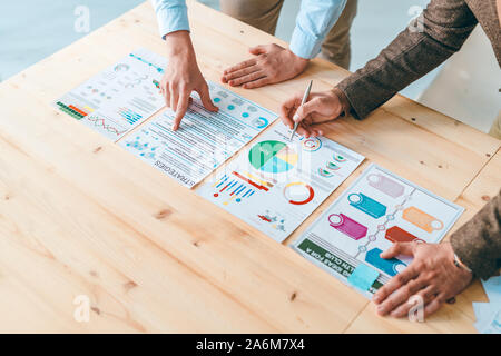 Zwei männliche Analysten und Ökonomen auf Dokumente mit Finanzinformationen Stockfoto