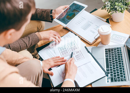 Einer der Entwickler erklärt seinen Kollegen die Vorteile des neuen Programms Stockfoto