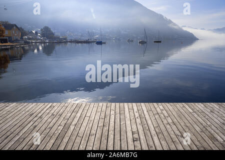 Blick auf die Boote mit Hintergrundbeleuchtung am Traunsee in Gmunden, OÖ, Austria verankert Mit der Grünberg im Hintergrund steigende Stockfoto
