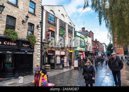 Dublin, Irland - 08 Dezember, 2018: die Menschen entlang einer Straße mit Kopfsteinpflaster mit Kneipen und Restaurants in der Altstadt bummeln ausgekleidet Stockfoto