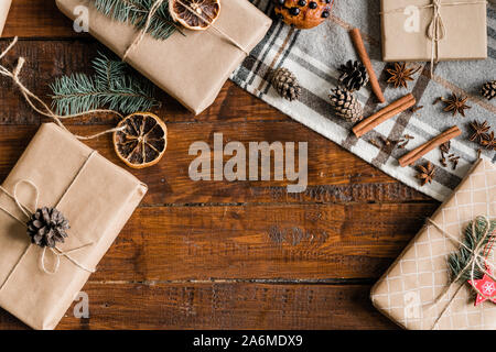 Boxen mit Weihnachtsgeschenke, kiefernzapfen, Dekorationen und Gewürzen auf hölzernen Tisch Stockfoto