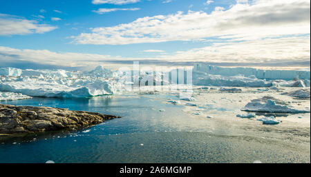 Eisberg und Eis vom Gletscher in den arktischen Natur Landschaft auf Grönland. Luftbild Drohne Bild von Eisbergen in Ilulissat Eisfjord. Durch den Klimawandel und die globale Erwärmung betroffen. Stockfoto