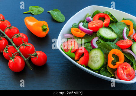 Salat von frischen Tomaten, Gurken, Zwiebel, Spinat, Pfeffer. Stockfoto