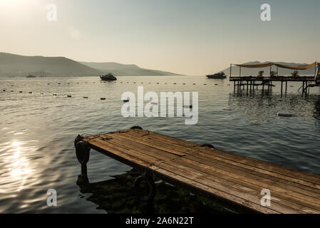 Panoramablick Sonnenaufgang Blick auf die Burg von Bodrum und Marina Bay auf Türkische Riviera von alten hölzernen Docks. Bodrum ist eine Stadt und ein Hafen City in Mugla Provinc Stockfoto