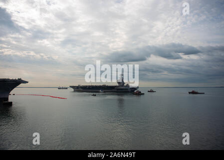 199104-N-XO 654-1226 Newport News, Virginia (Okt. 2010) 25, 2019) - USS Gerald R. Ford (CVN 78) leitet den Bug der stillgelegten Kitty Hawk-Klasse Flugzeugträger USS Enterprise (CVN 65) wie es in Gang kommt. Ford ging Huntington Ingalls Industries-Newport Nachrichten Schiffbau und zum Meer zurück zum ersten Mal seit Beginn der post-shakedown Verwendbarkeit im Juli 2018 Meer Studien durchzuführen. (U.S. Marine Foto von Mass Communication Specialist 3. Klasse Tatjana Freeman) Stockfoto