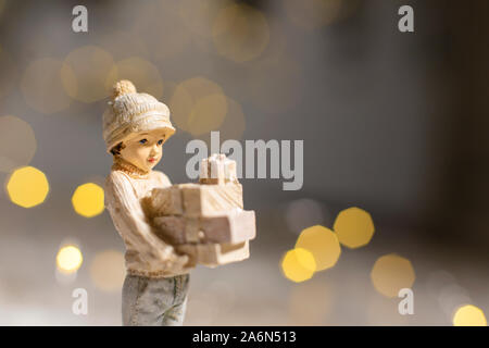 Die dekorativen Weihnachts-themed Figuren. Statue eines Mädchens holding Kartons mit Geschenken für Weihnachten in ihren Händen. Weihnachtsdekoration. Festliche Dez Stockfoto