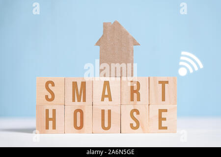 Abstrakte Pappe Haus auf Holz Buchstaben mit Inschriften. High Tech smart home Konzept. Close Up. Stockfoto