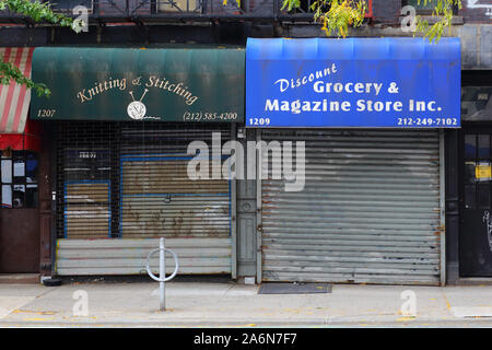 Zwei geschlossene und verschlossene Schaufenster mit zwei verschiedenen Sicherheitstoren im Viertel Upper East Side in Manhattan in New York City Stockfoto