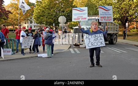 Ein Mann mit einer Trump-Maske und einem Schild, das "Eigentlich bin ich ein Crook"-Proteste vor Trump-Anhängern in Westerville, Ohio, USA angibt. Stockfoto