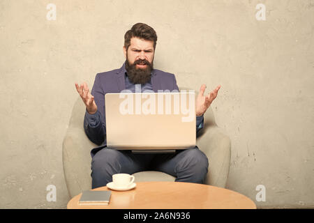 Probleme bei der Arbeit. Hipster Kaffee trinken und Arbeiten am Computer Arbeitsplatz. Bärtiger Mann seine Arbeit online tun. Weltweit arbeiten durch Abstand arbeiten. Stockfoto