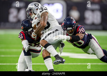 Houston, Texas, USA. 27 Okt, 2019. Oakland Raiders zurück laufen DeAndre Washington (33) ist durch die Houston Texans cornerback Gareon Conley (22) und starke Sicherheit Justin Reid (20) im vierten Quartal das Spiel bei NRG Stadion in Houston, Texas in Angriff genommen. Die endgültige Punktzahl 27-24 Texans. Maria Lysaker/CSM/Alamy leben Nachrichten Stockfoto