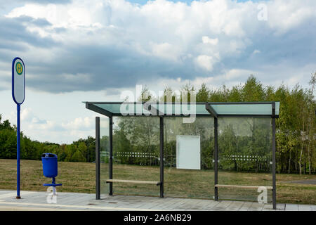 Moderne Bus-Stop mit Papierkorb mit bewölktem Himmel Stockfoto