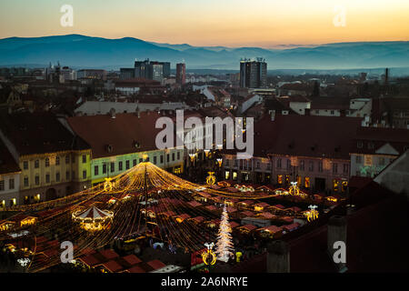 Sibiu, Rumänien - 30. November 2018. Sonnenuntergang über der traditionelle Weihnachtsmarkt in der historischen Altstadt von Sibiu, Siebenbürgen, Rumänien. Stockfoto