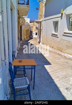 Tisch mit zwei Stühlen, in einer schmalen Gasse in Leros, Dodekanes, Griechenland. Stockfoto