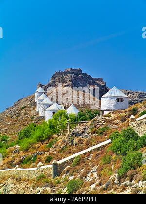 Die schönen traditionellen weißen Windmühlen auf einem Hügel in Leros, Griechenland. Mittelalterliche Burg von panteli oder Panteliou auf Hill Top. Stockfoto