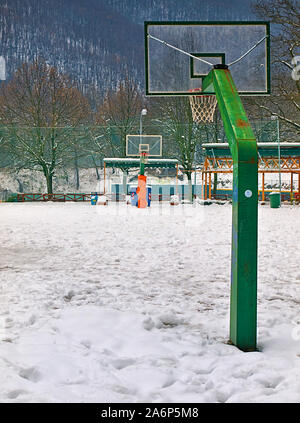 Basketball Feld mit Schnee bedeckt, in Agios Nikolaos (Sankt Nikolaus) Park in Syros Griechenland. Stockfoto