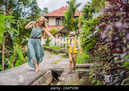 Mutter und Sohn Touristen in Bali Spaziergang entlang der schmalen gemütlichen Gassen von Ubud. Bali ist ein beliebtes Touristenziel. Reisen nach Bali Konzept. Reisen Stockfoto