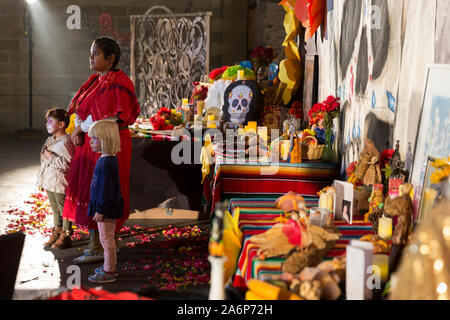 Ein Mitglied der Yakima Nation Swan Tänzer wartet mit zwei jungen Zuschauer an der Dia de los Muertos gemeinschaftlichen Feier in Tieton, Washington am Sonntag, 27. Oktober 2019 auszuführen. Tieton Kunst & Geisteswissenschaften Gastgeber der jährlichen Feier Freunde und Familienmitglieder, die gestorben sind, und zu helfen, ihren geistlichen Weg Unterstützung zu erinnern. Stockfoto