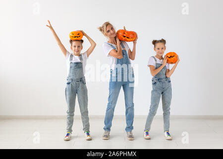 Happy Halloween und Feiertage Konzept - eine Mutter und ihre Töchter mit Kürbissen. Glückliche Familie Vorbereitungen für Halloween. Stockfoto