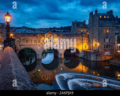 Pulteney-Brücke über den Fluss Avon in Bath mit Pulteney Wehr im Vordergrund, in der Dämmerung. Somerset. VEREINIGTES KÖNIGREICH Stockfoto