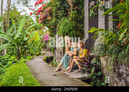 Mutter und Sohn Touristen in Bali Spaziergang entlang der schmalen gemütlichen Gassen von Ubud. Bali ist ein beliebtes Touristenziel. Reisen nach Bali Konzept. Reisen Stockfoto