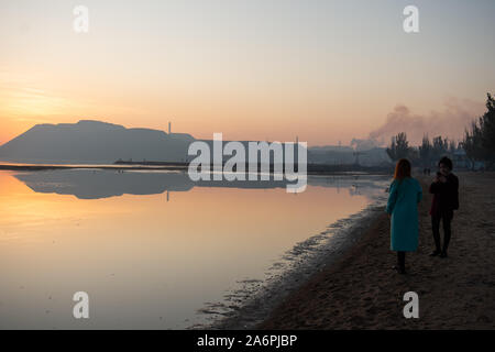 Mariupol, Ukraine. 24 Okt, 2019. Frauen nehmen Fotos am Ufer des Asowschen Meeres in Mariupol. Die zwei großen metallurgischen Anlagen in Mariupol basieren die Azovstal Eisen- und Stahlwerke und die iljitsch Eisen- und Stahlwerke Teil Метинвест Gruppe. Nach Angaben der ukrainischen Ökologie Bericht des Ministeriums im Jahr 2016 Iljitsch Anlage mehr als 1,7 Millionen Tonnen gefährlicher Emissionen in die Atmosphäre erzeugt und Asowschen Stal produziert 78.600 Tonnen atmosphärischer Schadstoffe und schüttete 1,4 Millionen Kubikmeter Abfall in das Asowsche Meer. Im Jahr 2018 des Ukrainischen Gesundheitsministeriums warnte die öffentlichkeit Schwimmen zu jeder o zu vermeiden. Stockfoto