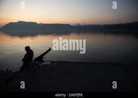 Mariupol, Ukraine. 24 Okt, 2019. Ein Mann angeln an den Ufern des Asowschen Meer in Mariupol. Die zwei großen metallurgischen Anlagen in Mariupol basieren die Azovstal Eisen- und Stahlwerke und die iljitsch Eisen- und Stahlwerke Teil Метинвест Gruppe. Nach Angaben der ukrainischen Ökologie Bericht des Ministeriums im Jahr 2016 Iljitsch Anlage mehr als 1,7 Millionen Tonnen gefährlicher Emissionen in die Atmosphäre erzeugt und Asowschen Stal produziert 78.600 Tonnen atmosphärischer Schadstoffe und schüttete 1,4 Millionen Kubikmeter Abfall in das Asowsche Meer. Im Jahr 2018 der Ukraine Gesundheit Ministerium gewarnt, das öffentliche Schwimmbad in Th zu vermeiden. Stockfoto