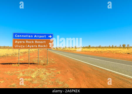 Uluru, Northern Territory, Australien - 22.August 2019: Lasseter Highway Schild Richtung Connellan Flughafen Ayers Rock Resort und Uluru. Tourismus in Stockfoto