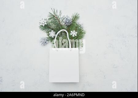 Weihnachten mock up flach mit weißen Paket und Tannenbaum und Schneeflocken auf weißem Holz- Hintergrund legen. Moderne Komposition für Winterurlaub design Stockfoto