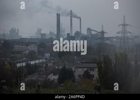 Ansicht des Asowschen Stal Stahlwerk in Mariupol. Die zwei großen metallurgischen Anlagen in Mariupol basieren die Azovstal Eisen- und Stahlwerke und die iljitsch Eisen- und Stahlwerke Teil Метинвест Gruppe. Nach Angaben der ukrainischen Ökologie Bericht des Ministeriums im Jahr 2016 Iljitsch Anlage mehr als 1,7 Millionen Tonnen gefährlicher Emissionen in die Atmosphäre erzeugt und Asowschen Stal produziert 78.600 Tonnen atmosphärischer Schadstoffe und schüttete 1,4 Millionen Kubikmeter Abfall in das Asowsche Meer. Im Jahr 2018 des Ukrainischen Gesundheitsministeriums warnte die öffentlichkeit Schwimmen an einem der Strände um Mariupol zu vermeiden. Stockfoto