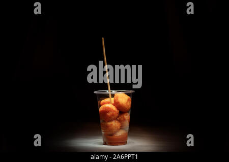 Kwek-Kwek/Tokneneng - eine philippinische Tempura - wie Straße Essen in Schale aus Kunststoff mit Stick in Schwarz isoliert Hintergrund. Stockfoto