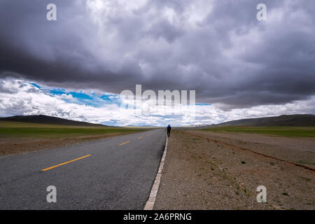 Vorwärtsfahrt Konzept Hintergrund - asphaltierte Straße auf Ebene im Himalaya mit Bergen und dramatische Wolken. Stockfoto