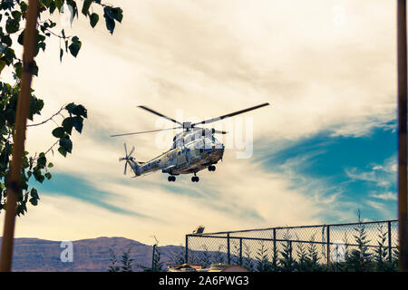 Moderne taktische Hubschrauber weg fliegen. Der Häcksler ist mit neuer Technologie für taktische Kriegsführung gefüllt. Bewölkt blauer Himmel im Hintergrund. Stockfoto