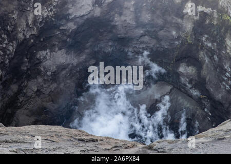 Detailansicht der Innenraum des Mount Bromo Krater, Ostjava, Indonesien. Weiß vulkanisches Gas steigt von unten; gelber Schwefel in der Felswand in eingebettet Stockfoto