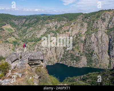 Wanderer auf einem Felsen über dem Fluss Sil Canyon, Ribeira Sacra im Bereich der Parada de Sil, Ourense, Galizien, Spanien Stockfoto