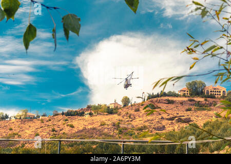 Moderne taktische Hubschrauber weg fliegen. Der Häcksler ist mit neuer Technologie für taktische Kriegsführung gefüllt. Bewölkt blauer Himmel im Hintergrund. Stockfoto