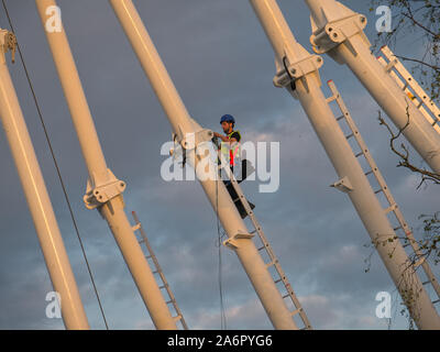 Ein Bauarbeiter in Cardiff, Wales, UK in der Höhe auf Stahl arbeiten mit großen Hohlprofile mit Sicherheit Kabelbäume und andere Geräte. Stockfoto