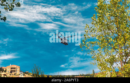 Moderne taktische Hubschrauber weg fliegen. Der Häcksler ist mit neuer Technologie für taktische Kriegsführung gefüllt. Bewölkt blauer Himmel im Hintergrund. Stockfoto