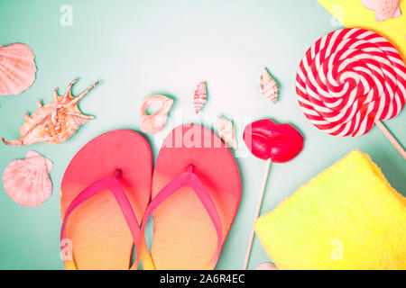 Helle Flip Flops mit Muscheln und roten Lutscher in Form der Lippen auf Minze Hintergrund. Flach Komposition. Strand, Sommer, Urlaub, Meer, Ferienhäuser co Stockfoto