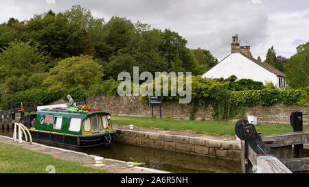 15-04 (schmale Boot) segeln am malerischen ländlichen Leeds Liverpool Canal, vorbei an Schloss (1 Mann durch Tore) - Gargrave, North Yorkshire, England, Großbritannien Stockfoto